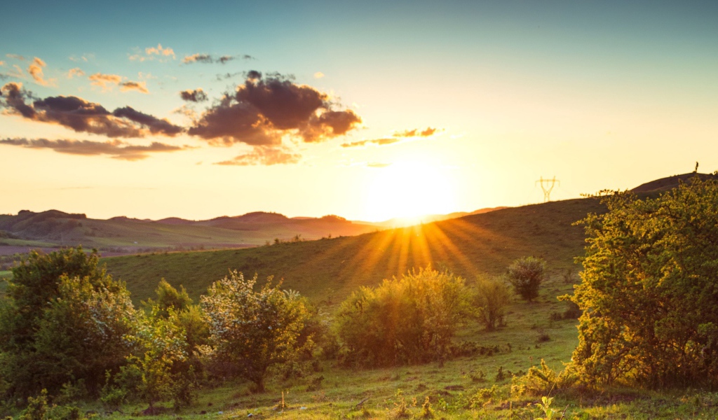 Яркое летнее солнце встает из-за гор 