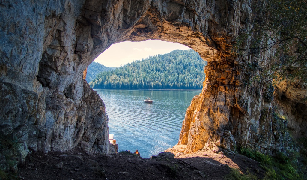 Проход арка в скале ведет к озеру
