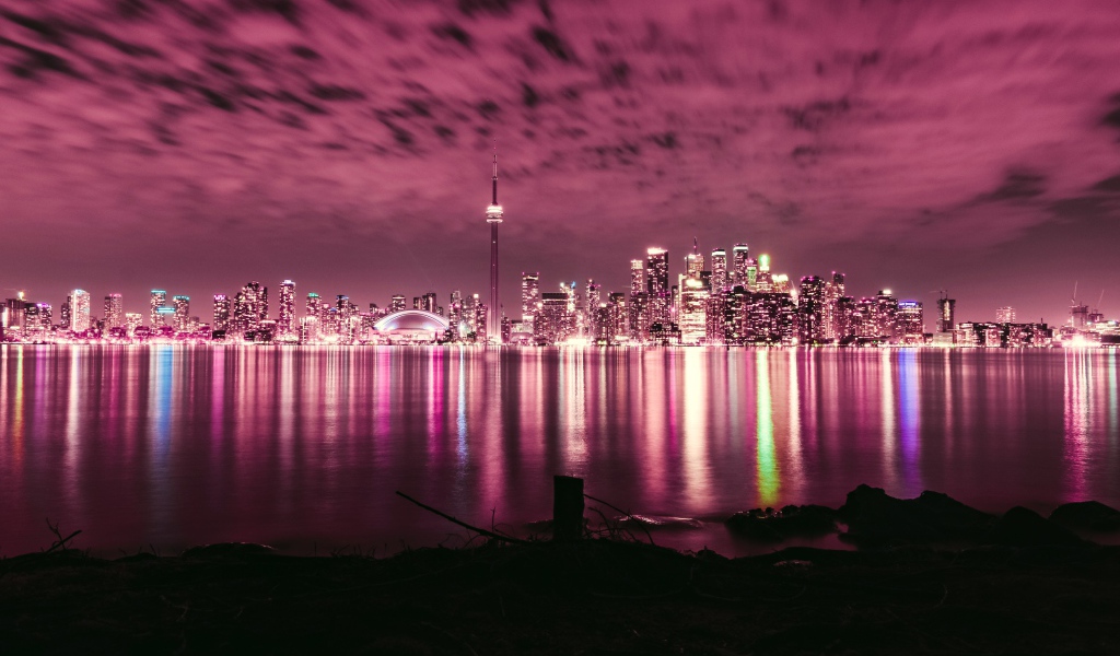 Ночной город под голубым небом отражается в воде 