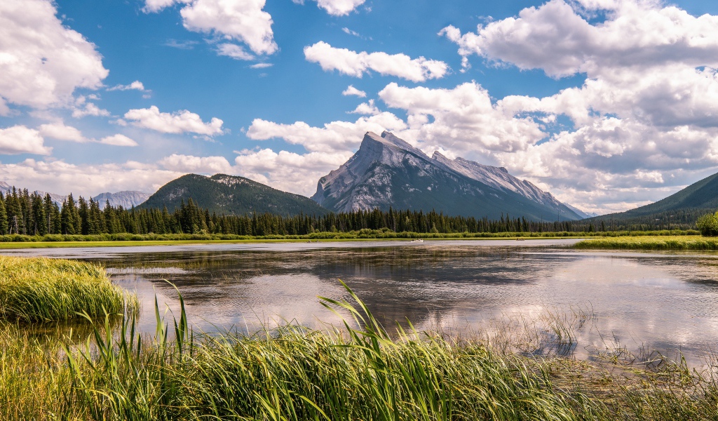 Красивое горное озеро под голубым небом с белыми облаками
