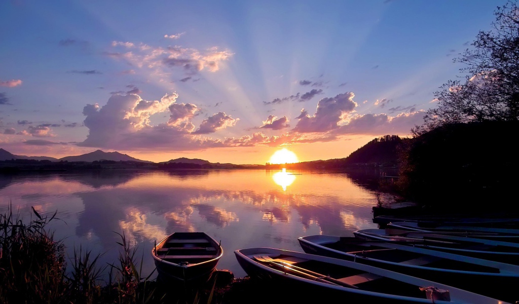 Лодки на берегу озера на закате солнца