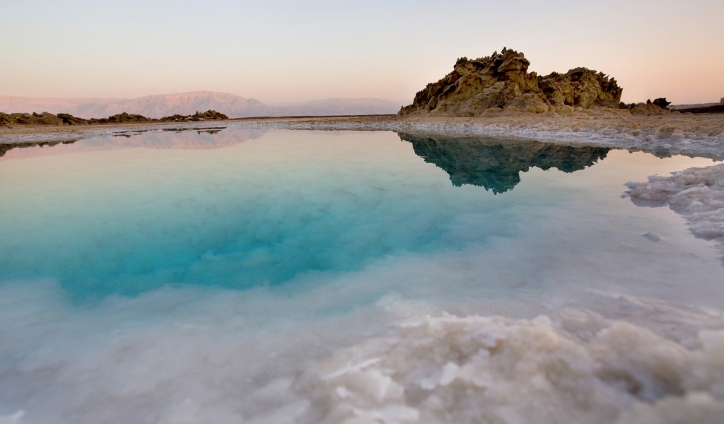 Покрытые льдом берега горного озера с голубой водой