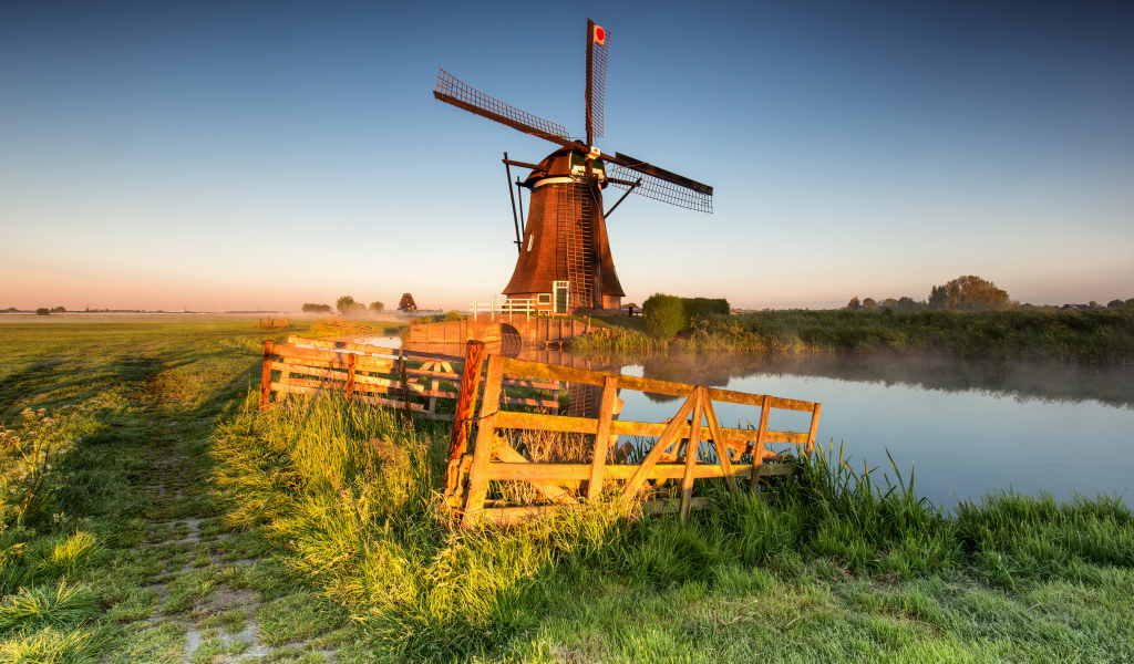 Старая мельница на берегу озера на ферме 