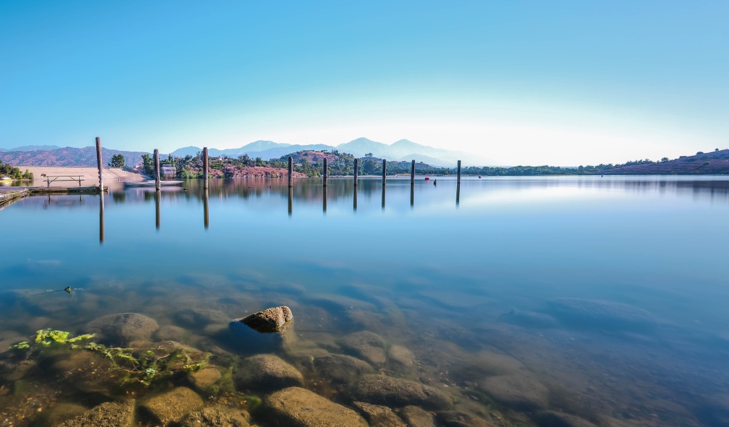 Камни в озере на фоне голубого неба