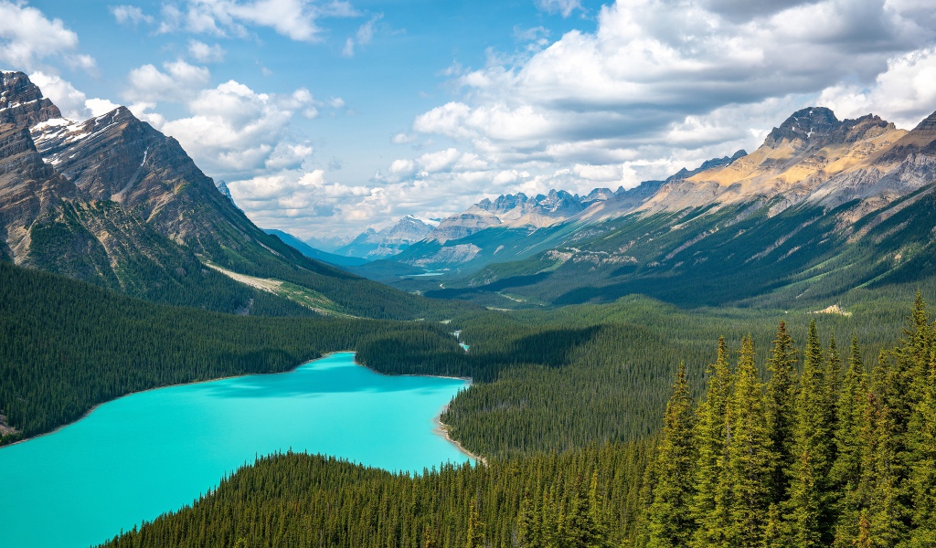 View of a beautiful blue lake and mountain valley under a sunny sky with white clouds