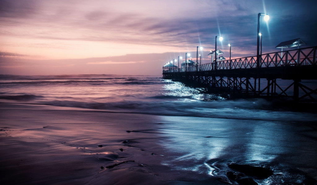 Вид на мост в океане с включенными фонарями ночью