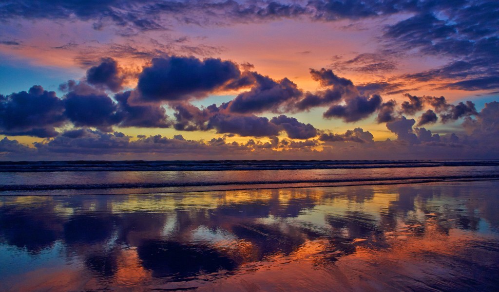 Черные тучи отражаются в морской воде на закате