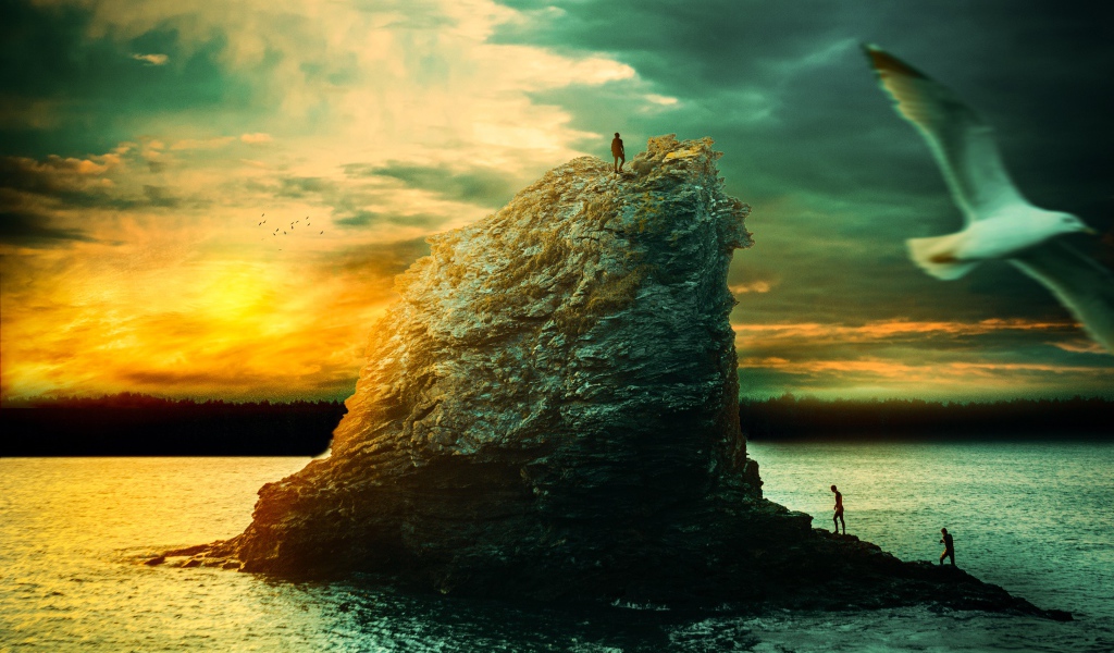 Скала в море на закате солнца