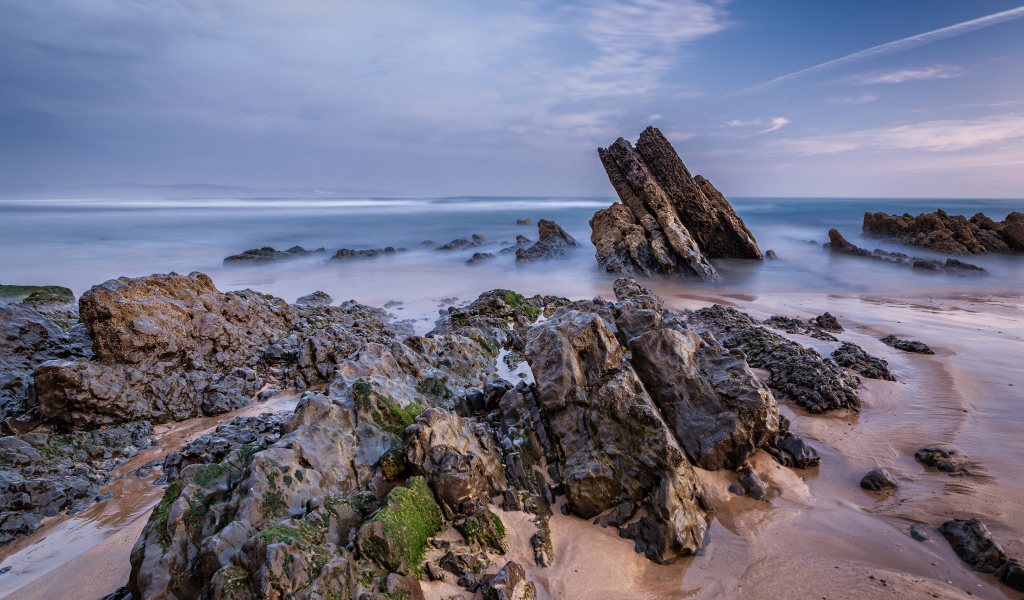 Туман над холодным утренним морем с камнями на берегу 