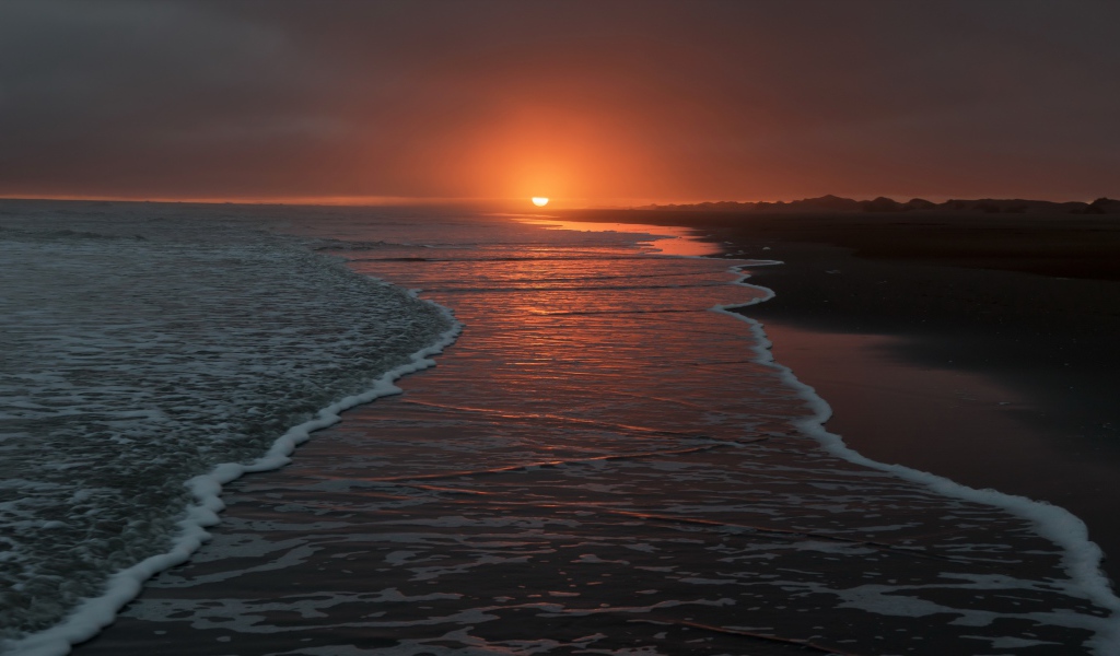 Тихие волны на берегу моря на закате