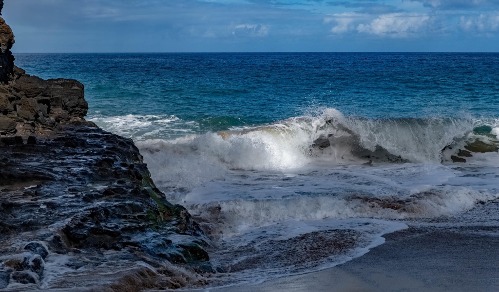 Бушующие белые волны в море у скал 