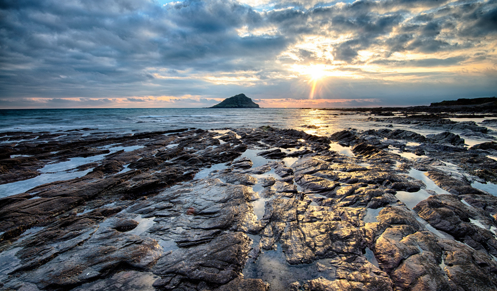 Каменный берег океана в лучах солнца