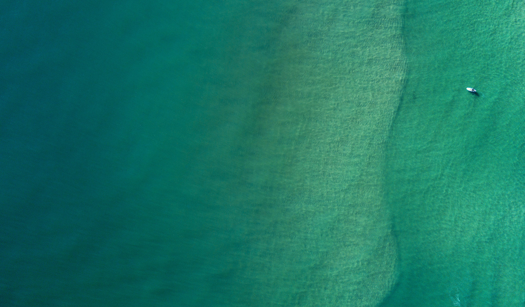 Вид сверху на спокойную голубую гладь океана