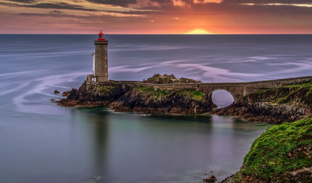 Вид на спокойное море и маяк на закате солнца 