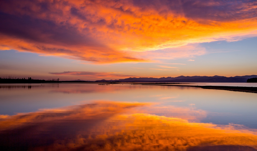 Красивое небо на закате отражается в спокойной воде озера