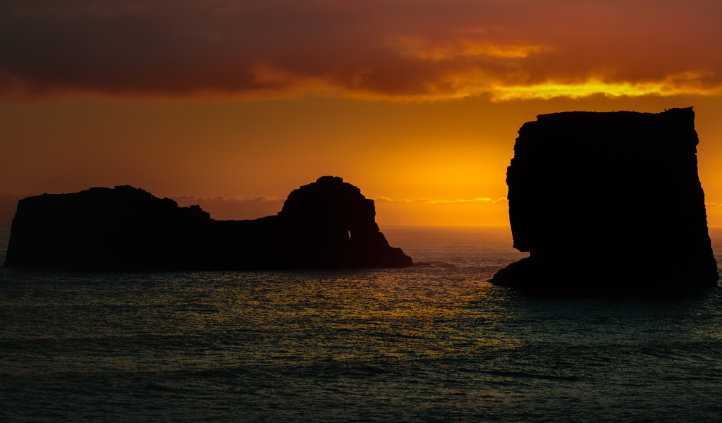 Скалы в море на закате солнца  