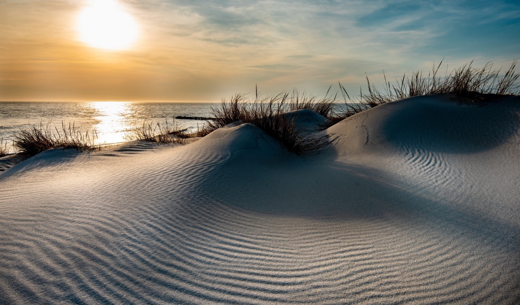 Горячий песок на берегу моря на закате 