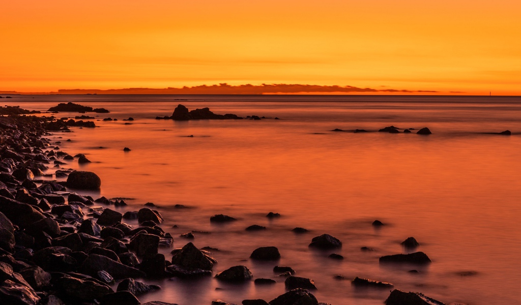 Камни на берегу моря на закате в сумерках 