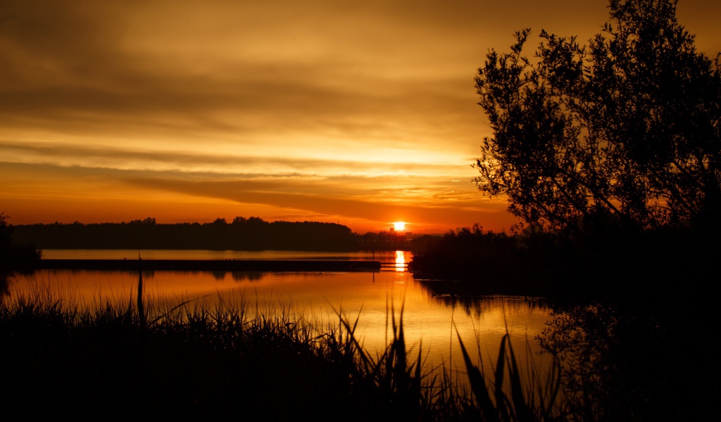 Закат яркого осеннего солнца над рекой 