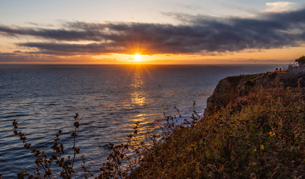 Вид на закат солнца в темных облаках в небе над морем 