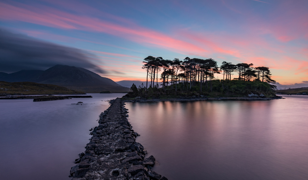 Дорога ведет к острову на фоне голубого заката