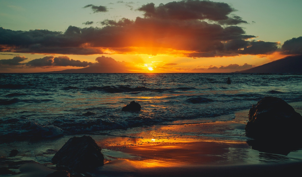 Мокрый песок на берегу океана на закате