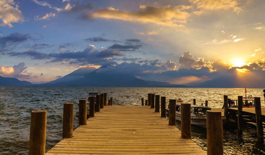 Деревянный мост в море на закате солнца 