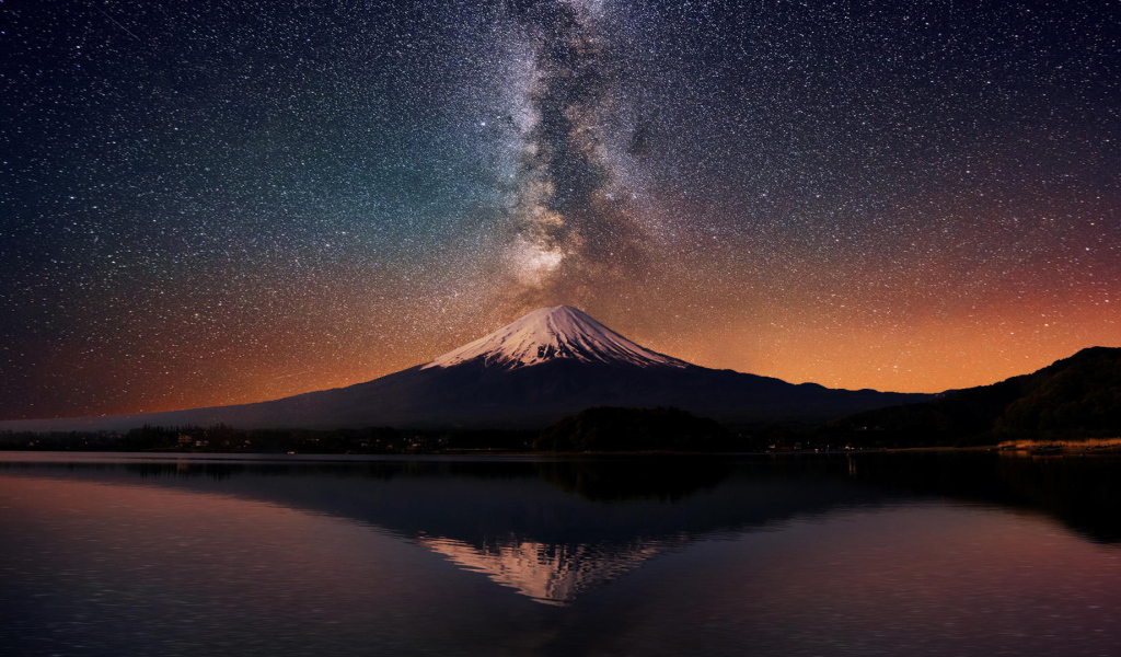 Заснеженная вершина вулкана под звездным небом