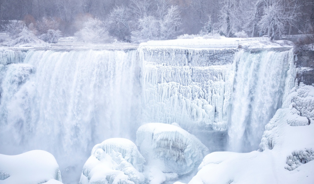 Замерзший водопад стекает по камням зимой
