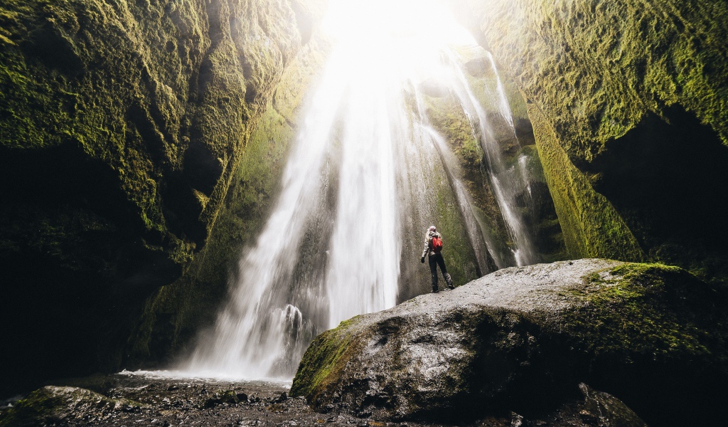 Быстрый водопад стекает между скал 