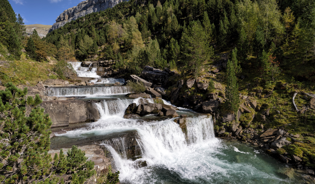 Красивые каскады водопада у скалы 