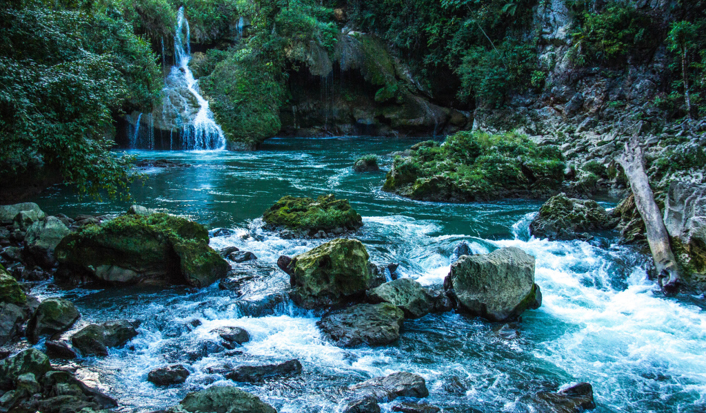 Голубая вода в водопаде стекает по камням 