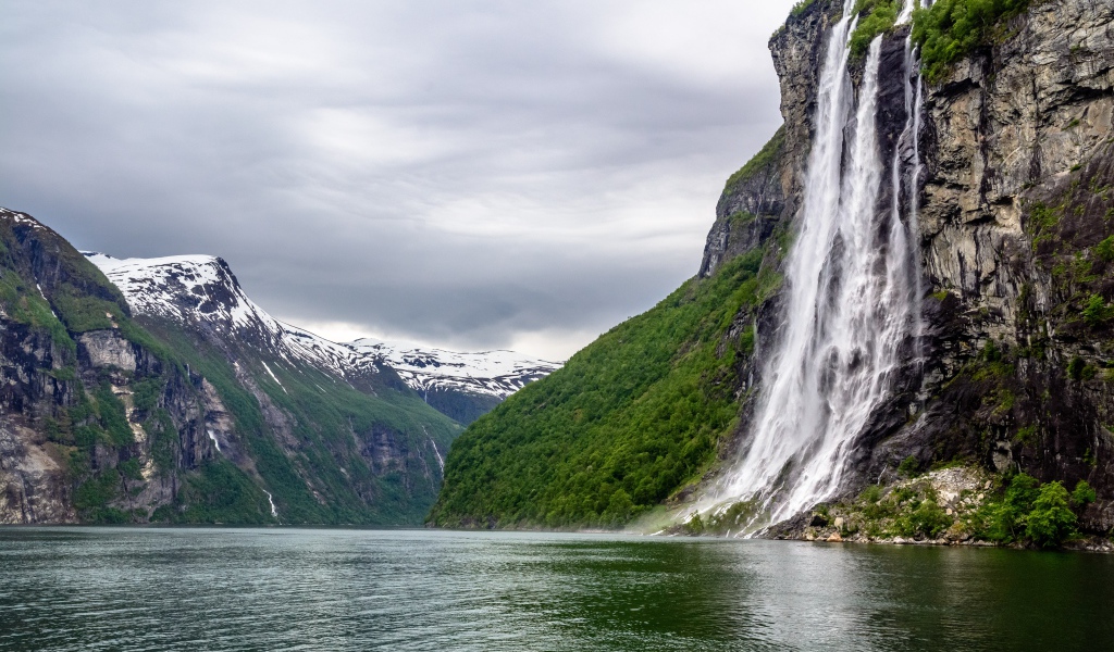 Водопад стекает с утеса в озеро, Норвегия