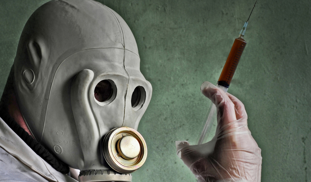 Мужчина в противогазе со шприцем в руках, пандемия коронавирус