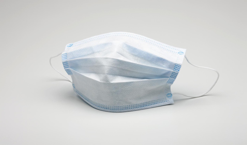 Медицинская маска защита от коронавирус covid-19 на сером фоне