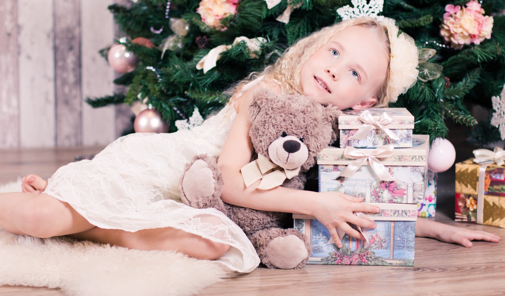 Красивая голубоглазая девочка с подарками у елки
