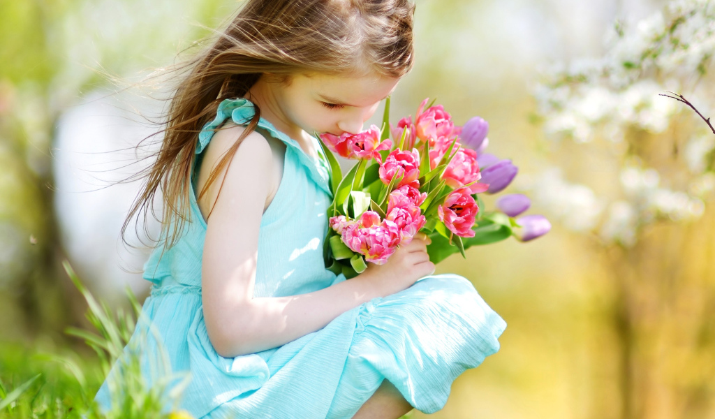 Красивая девочка в голубом платье с букетом тюльпанов