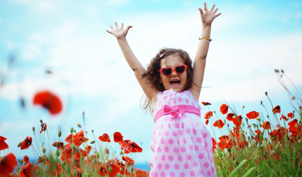 Счастливая маленькая девочка в платье на поле с маками