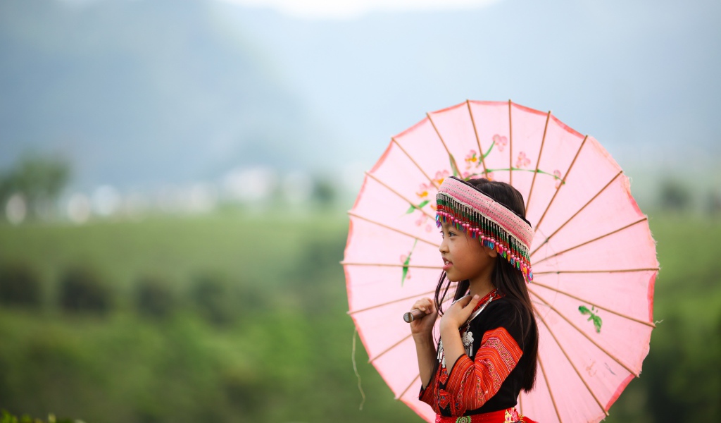 Маленькая девочка азиатка в розовым зонтом