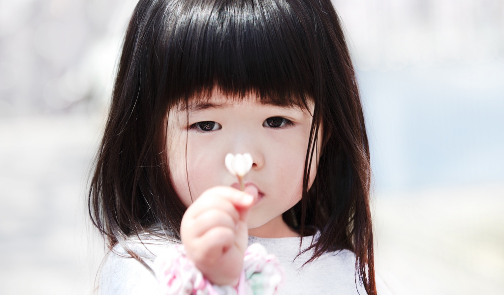 Маленькая девочка азиатка с цветком