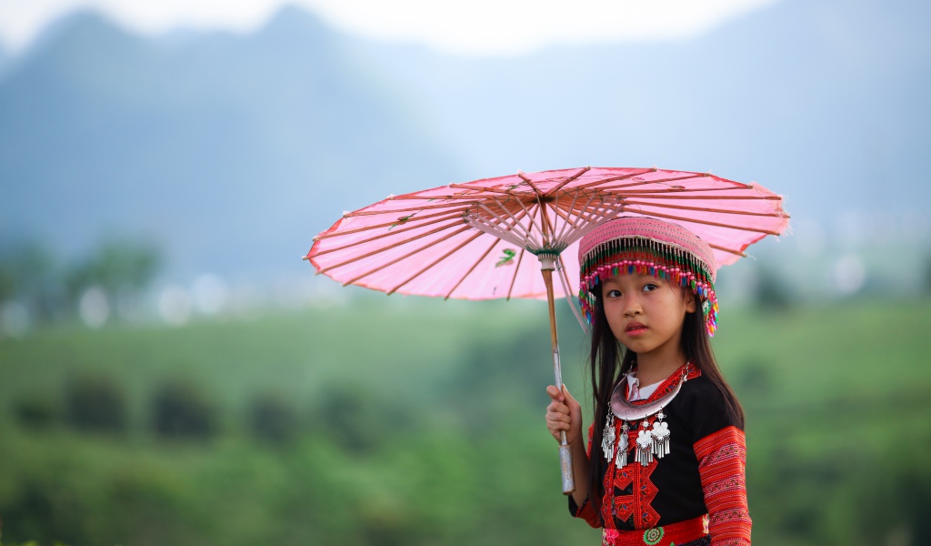 Маленькая девочка азиатка с розовым зонтом