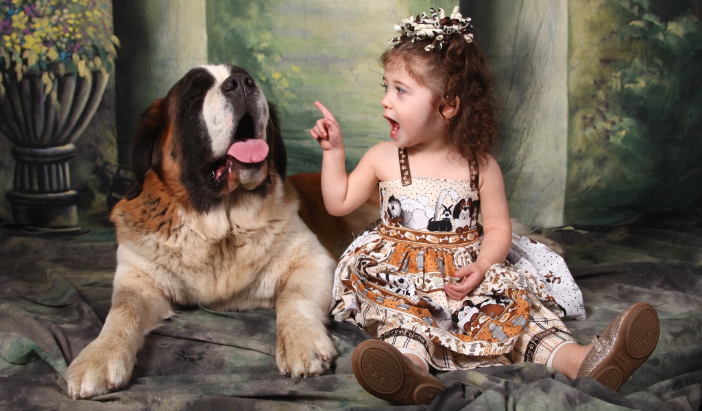 Маленькая красивая девочка с собакой породы сенбернар