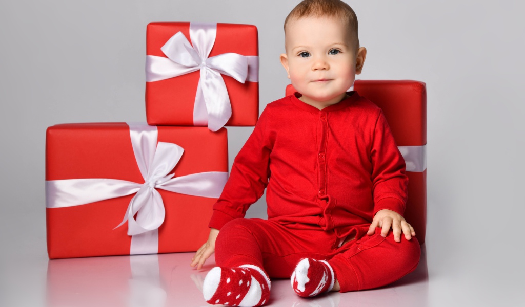 Маленький мальчик в красном костюме с подарками