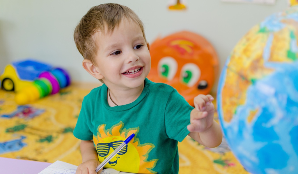 Маленький мальчик изучает глобус 