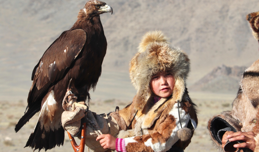 Маленький ребенок на охоте с хищным орлом