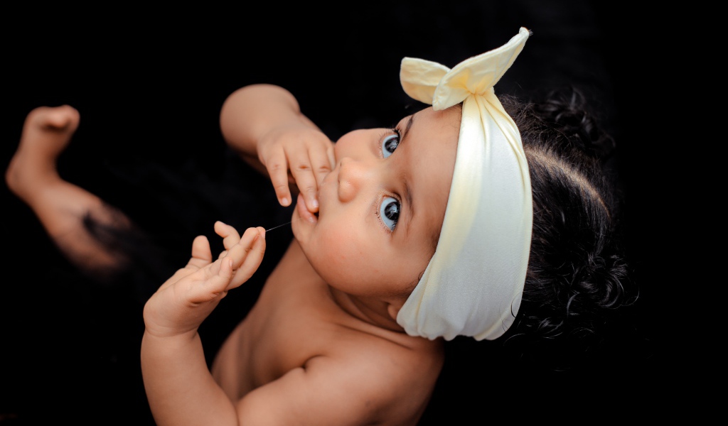 Маленькая темноволосая девочка с бантом на голове 