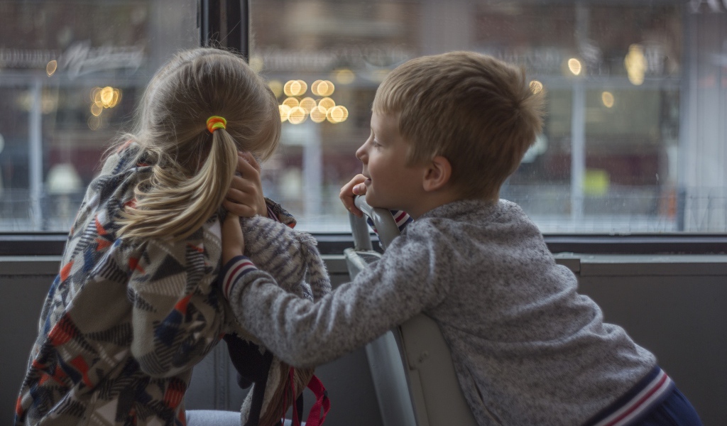 Маленькие девочка и мальчик сидят в автобусе 