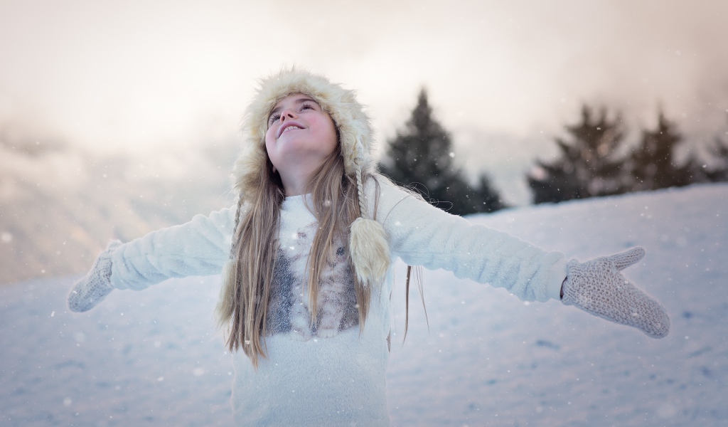 Маленькая девочка в теплой шапке на улице зимой