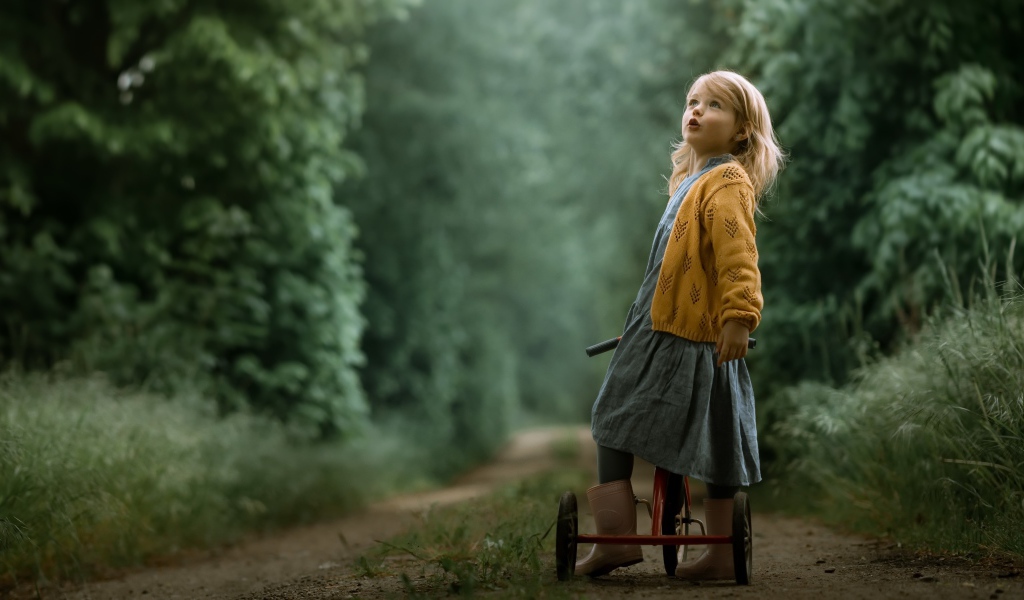 Маленькая девочка на трехколесном велосипеде 