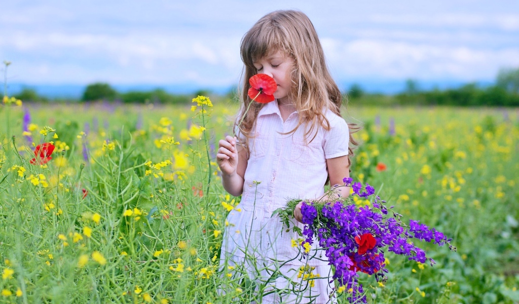 Маленькая девочка с букетом полевых цветов 